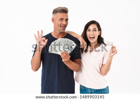 Picture of emotional surprised adult loving couple isolated over white wall background holding money and credit card.