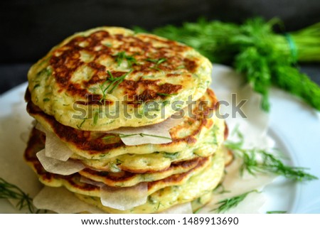 Appetizing pancakes. A photo of food in low key. Pancakes with parsley and chives. Ukrainian and Russian cuisine. Food on a black background. Pancake week. green onion cakes