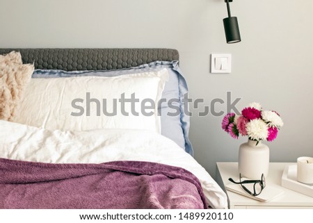 Modern bedroom in the morning with flowers on the nightstand