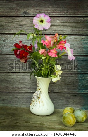 garden flowers in a porcelain vase on the background of wooden boards
