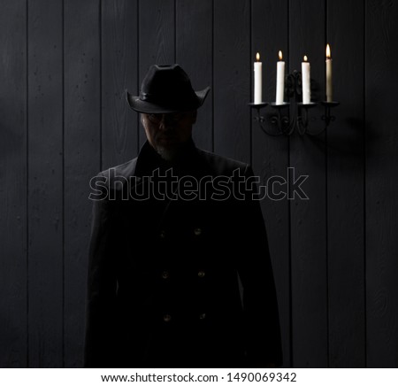 incognito portrait in hat by candlelight