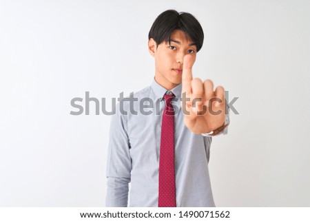 Chinese businessman wearing elegant tie standing over isolated white background Pointing with finger up and angry expression, showing no gesture