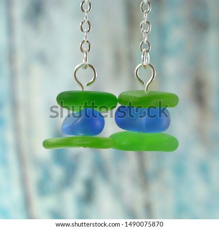 Sea glass dangle earrings of rustic background. Close up. Handmade jewelry. Royalty-Free Stock Photo #1490075870