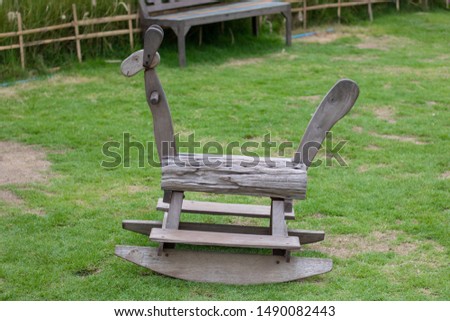 Wooden rocking horse in the green lawn