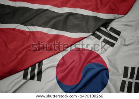 waving colorful flag of south korea and national flag of trinidad and tobago. macro