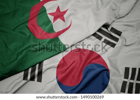 waving colorful flag of south korea and national flag of algeria. macro