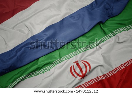 waving colorful flag of iran and national flag of netherlands. macro