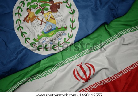 waving colorful flag of iran and national flag of belize. macro