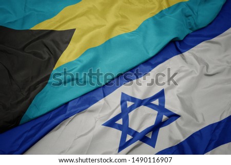 waving colorful flag of israel and national flag of bahamas. macro