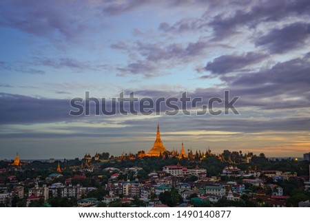 The cityscape of Yangon with Shwedagon and dramatic sunset sky during twilight