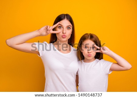 Portrait of two nice attractive comic childish funky cheerful glad positive person mommy showing v-sign having fun holiday isolated over bright vivid shine yellow background