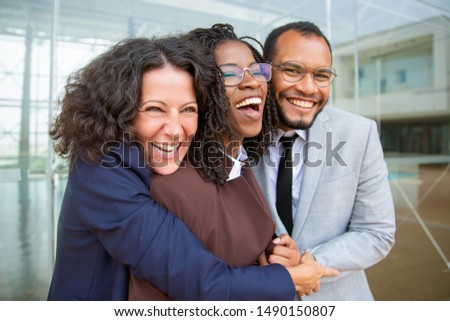 Happy business colleagues hugging. Cheerful multiethnic business people in formal wear hugging and laughing. Cooperation concept Royalty-Free Stock Photo #1490150807