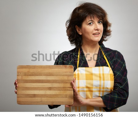 Woman cook holding a wooden board with copyspace