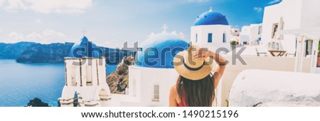 Summer travel tourist visiting Oia, Santorini, Europe vacation destination. Luxury holiday woman walking in city. Banner panorama.