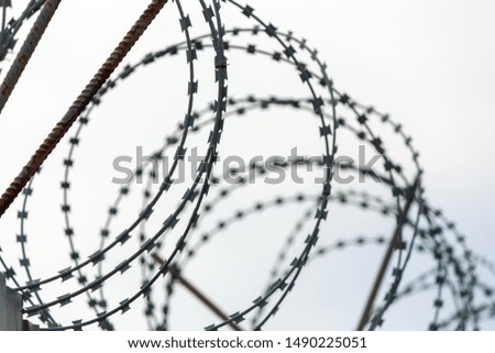 barbed wire on fence on sky background