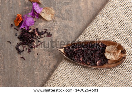 Dehydrated hibisco leaves, chopped, in the natural bark. Antioxidants. Wood color background. Top view. From above. Space for text. Royalty-Free Stock Photo #1490264681