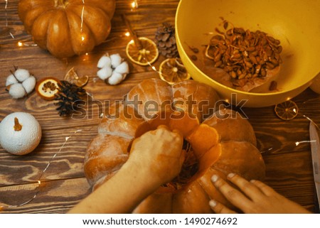 Close-up of Man's hands carve pumpkin for Halloween on wooden rustic table. Halloween autumn concept.