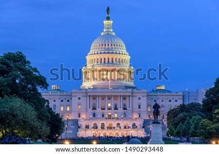 Summer Night at Capitol Hill - A dusk view of west-side of U.S. Capitol Building, as a small crowd gathering around a summer concert at front, Washington, D.C., USA. No recognizable log or person. Royalty-Free Stock Photo #1490293448