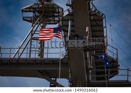 The American flag flies from the mast of a US aircraft carrier.