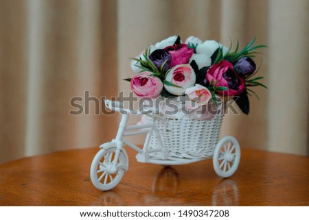 artificial flowers in decorative pot in the form of a bicycle. Close-up, shallow depth of field