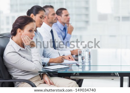 Businesswoman in bright office getting bored while attending presentation