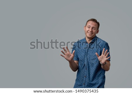 A man in a shirt with an apologetic expression on a gray background. Concept banner for advertising, copy space, gray background, commercial design