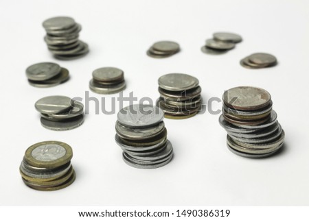 Coins placed high, low, and have a reflection on the bottom. on the White Blackground