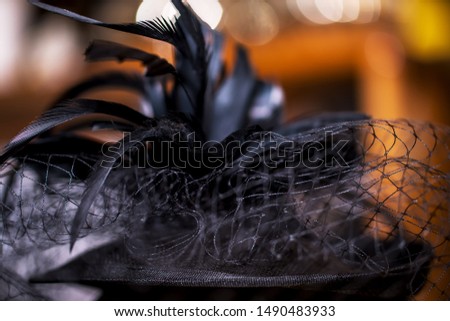 Black Teardrop Funeral Hat with Veil and Feathers on brown background