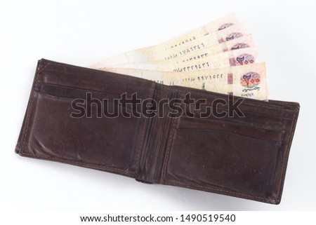 200 Egyptian pound bills in a dark brown wallet isolated on a white background  Royalty-Free Stock Photo #1490519540