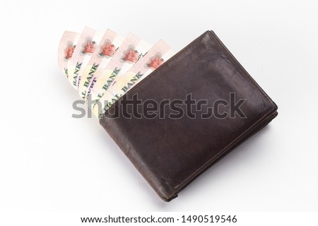 200 Egyptian pound bills in a dark brown wallet isolated on a white background  Royalty-Free Stock Photo #1490519546