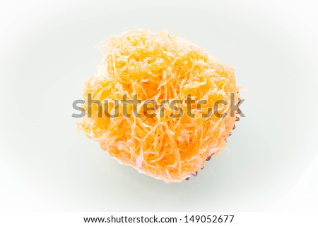 Gold egg yolk thread topped on cup cake, stock photo