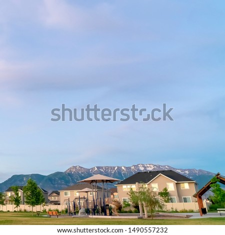 Square Scenic view of a neighborhood with towering mountain and cloudy sky background