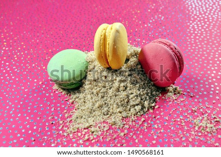 Cake Macarons dessert and Christmas background. french macaroon on a heap of almond flour on pink background with dots. colorful almond cookies. Merry Christmas card. New year mood