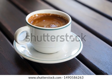 Mug of strong, Turkish, Greek coffee, espresso on a wooden background in natural light with space for text