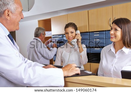 Busy reception in a hospital with doctors and receptionists Royalty-Free Stock Photo #149060174