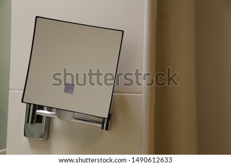 square mirror on the ceramic wall of the bathroom, interior