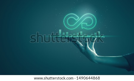 Circular economy with infinite concept. Business man showing arrow infinity symbol with neon light and dark background. Graph showing the earnings, profits of business shares in good feedback. Royalty-Free Stock Photo #1490644868