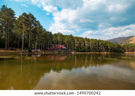 Reflection of the house on the lake with an amazing forest view. Location: Sandras Mountain, Turkey
