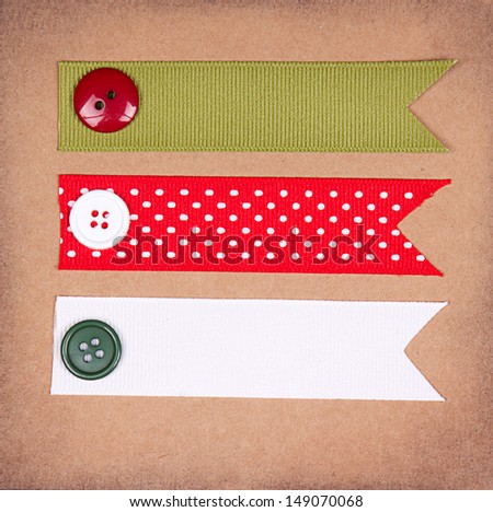 Christmas ribbon tags with buttons on scrapbook paper background