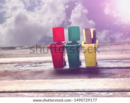 Colorful trash can on old wood plank,dimly light,with lens flare.Waste sorting behaviour and Environment concept,with space for your text design and your product display.
