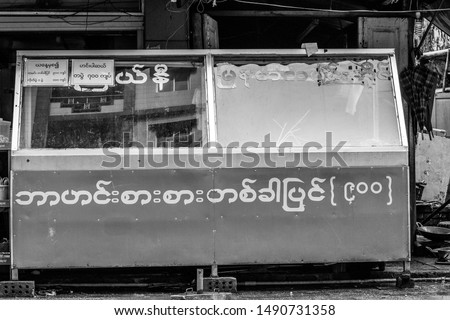 Street side Burmese curry shop in Yangon, Myanmar in black and white. Text reads: '900 [mmk] for any dish;' 'Starting today all dishes will be 900, and 100 for an extra."