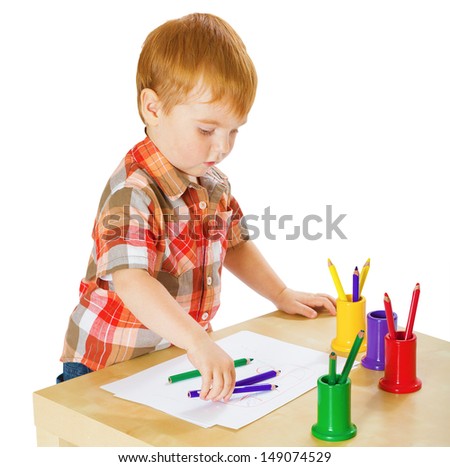 Portrait of a cute preschool boy drawing isolated on white background