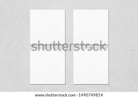 Four empty white square business card mockups with soft shadows on neutral light grey concrete background. Flat lay, top view