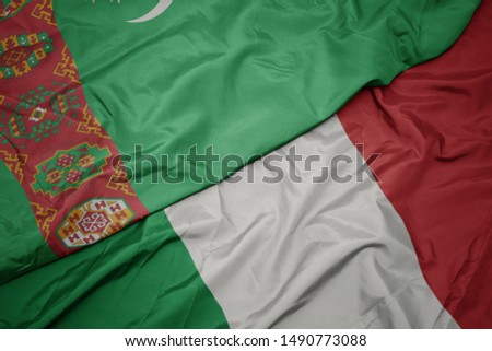 waving colorful flag of italy and national flag of turkmenistan. macro