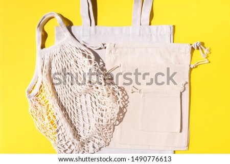 Mesh and cotton bags with on yellow background. Sustainable lifestyle. Zero waste concept. No plastic