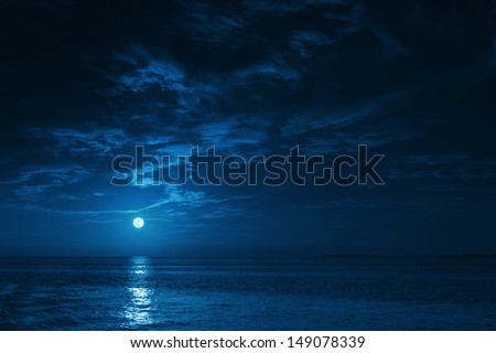 This photo illustration of a deep blue moonlit ocean at night with calm waves would make a great travel background for any coastal region or vacation. Royalty-Free Stock Photo #149078339