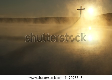 This Sunrise Cross on a misty lake casts a lengthy shadow and reflection on this calm Easter Morning Illustration