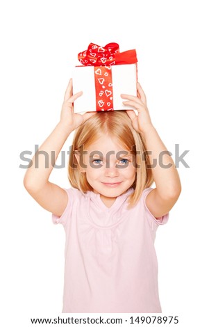 Pretty little girl with gift on head. Festive concept. Isolated on white background