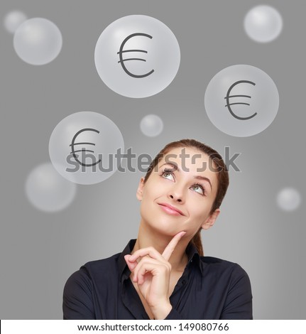 Thinking happy woman looking up on euro signs above on grey background