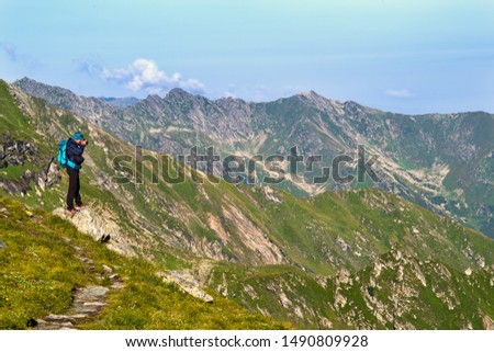 Young tourist taking picture in mountain, Romanian Carpathians